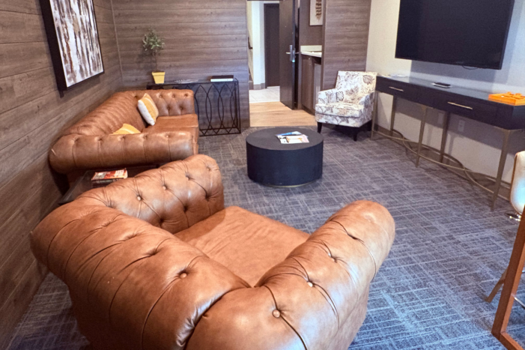 Lounge with armchairs, a sofa, and paneled walls